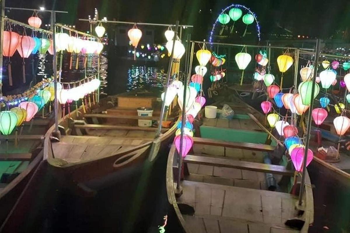 una barca con lanterne colorate sull'acqua di notte