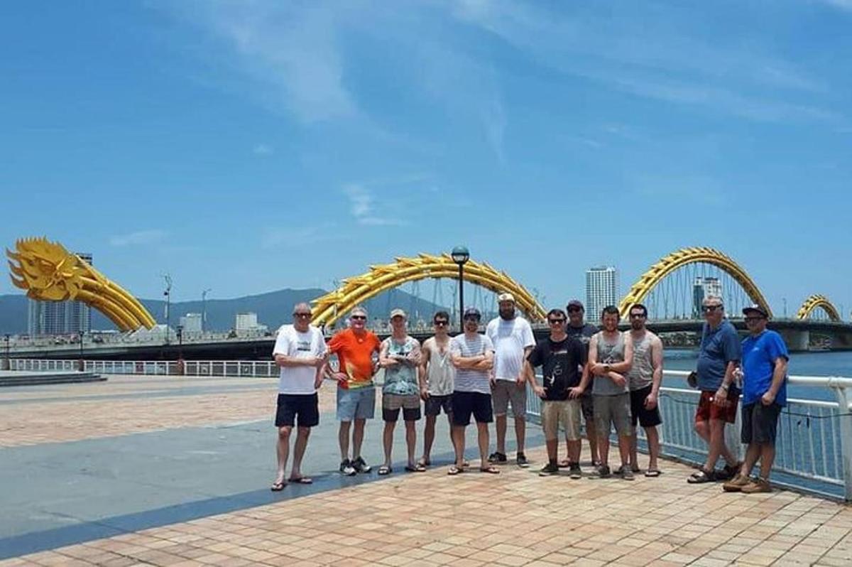 un gruppo di persone in posa davanti alle montagne russe