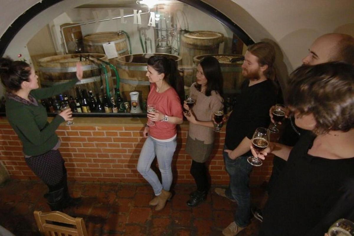 skupina lidí stojících kolem baru a držících sklenice na víno