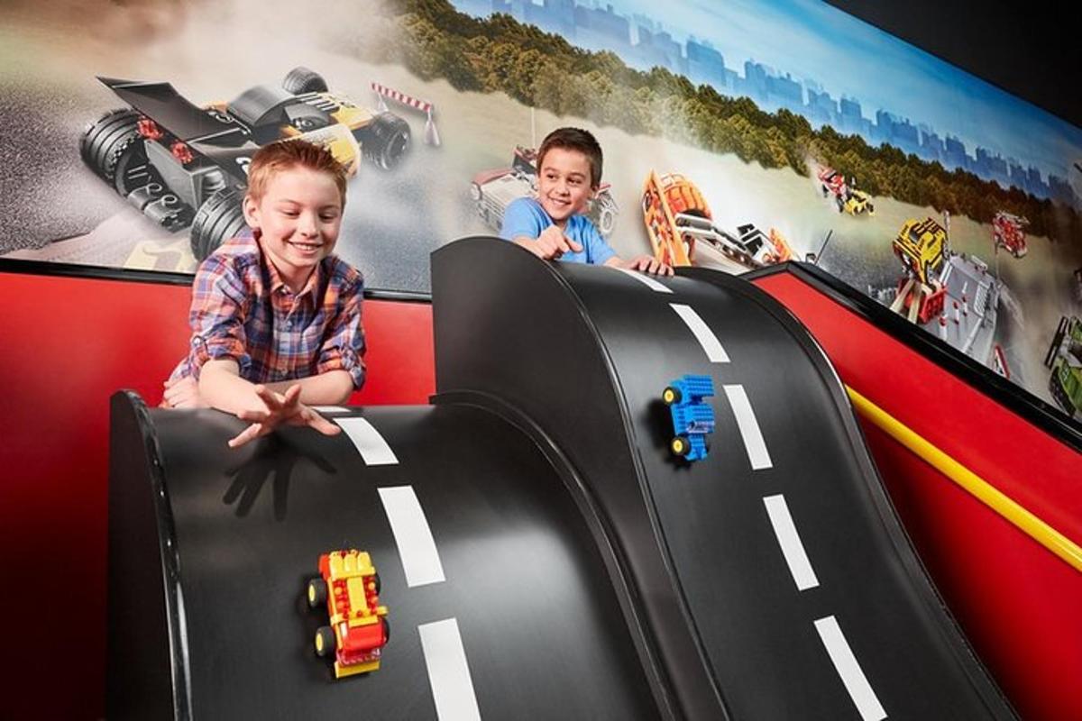two young children playing with toy cars on a roller coaster
