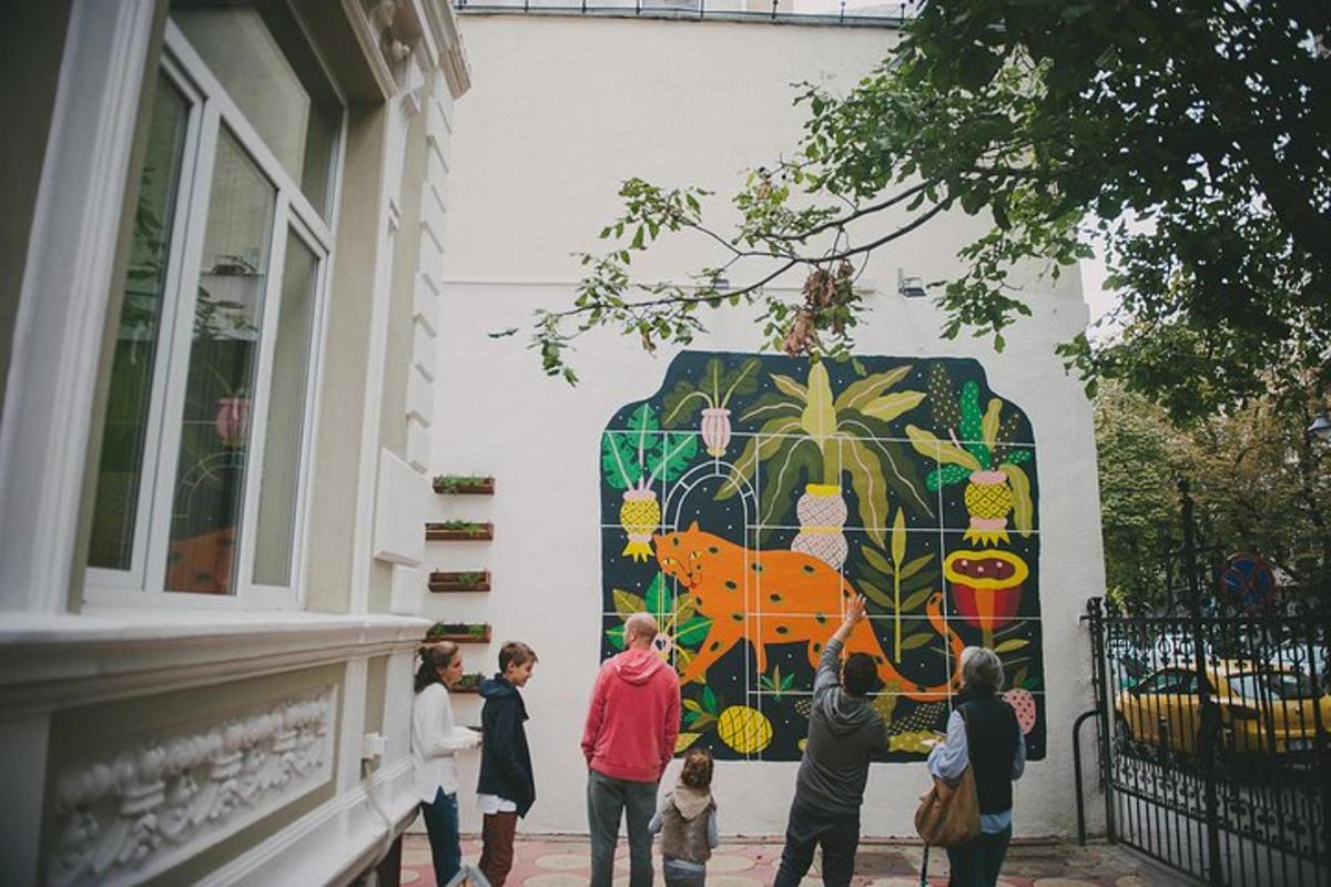 a group of people looking at a mural on a wall