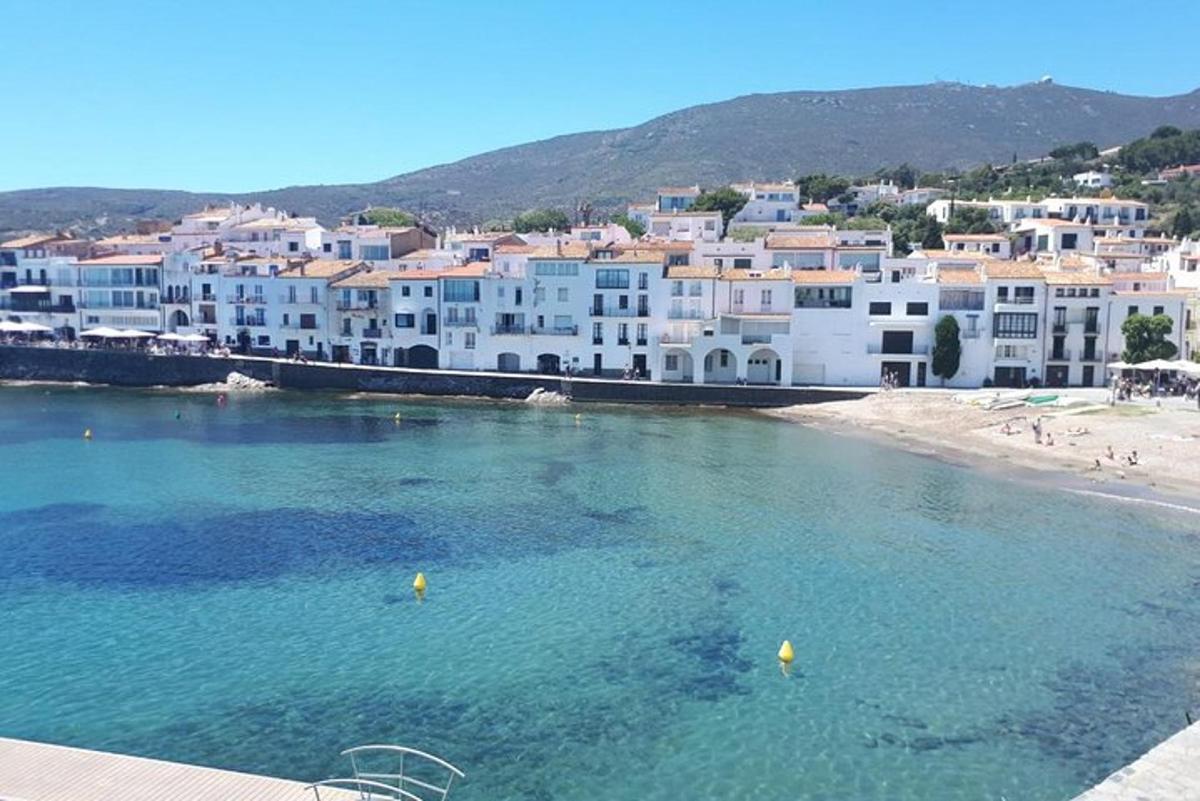 a group of white buildings on a beach with water