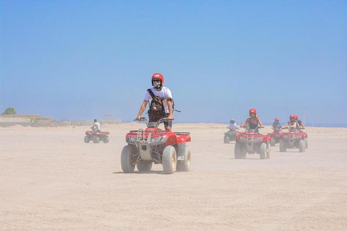 sekelompok orang mengendarai ATV di padang pasir