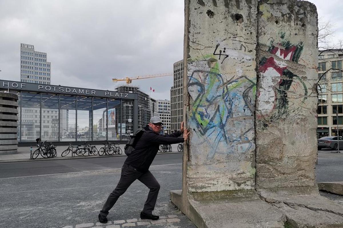 um homem parado ao lado de uma parede com grafite