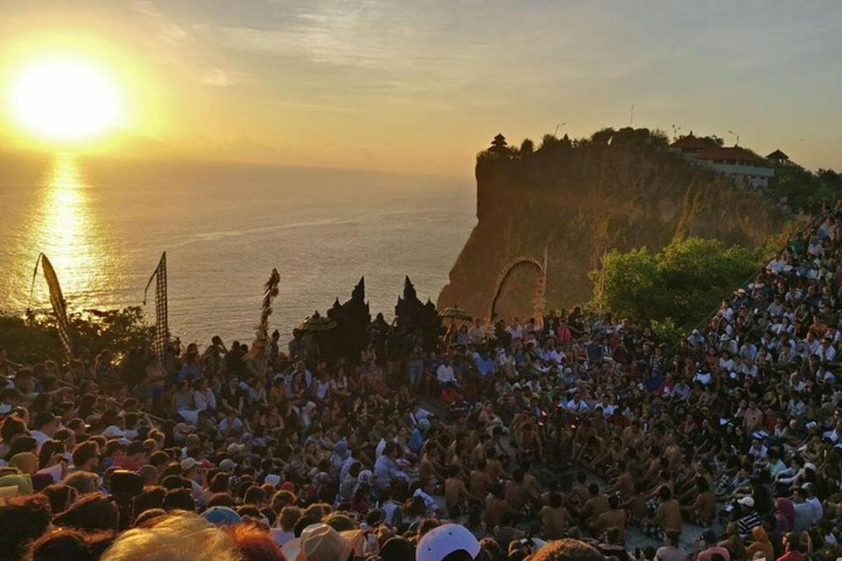 uma grande multidão de pessoas assistindo ao pôr do sol