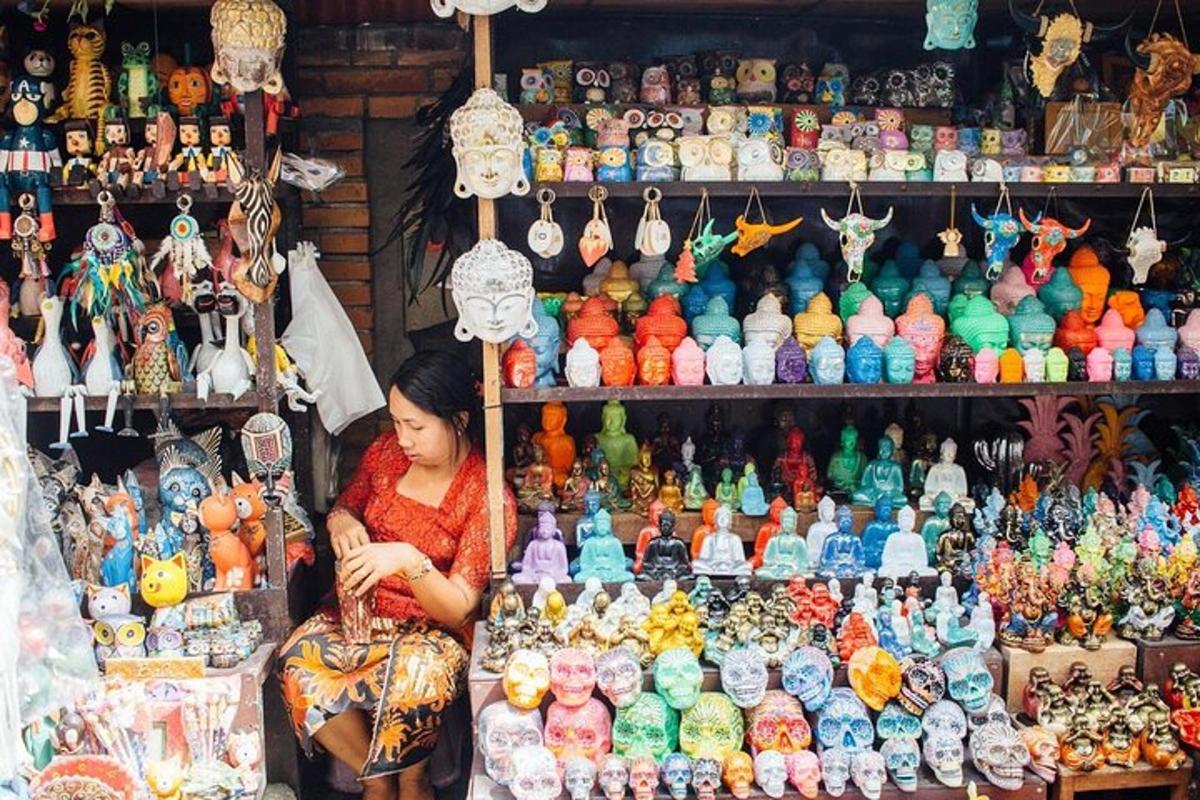 Una mujer sentada frente a una tienda llena de figuritas.
