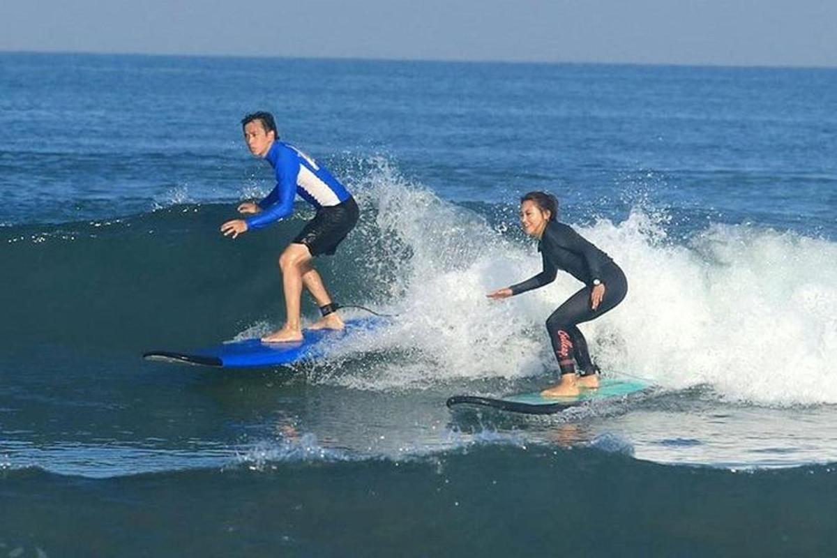 two men riding a wave on surfboards in the ocean