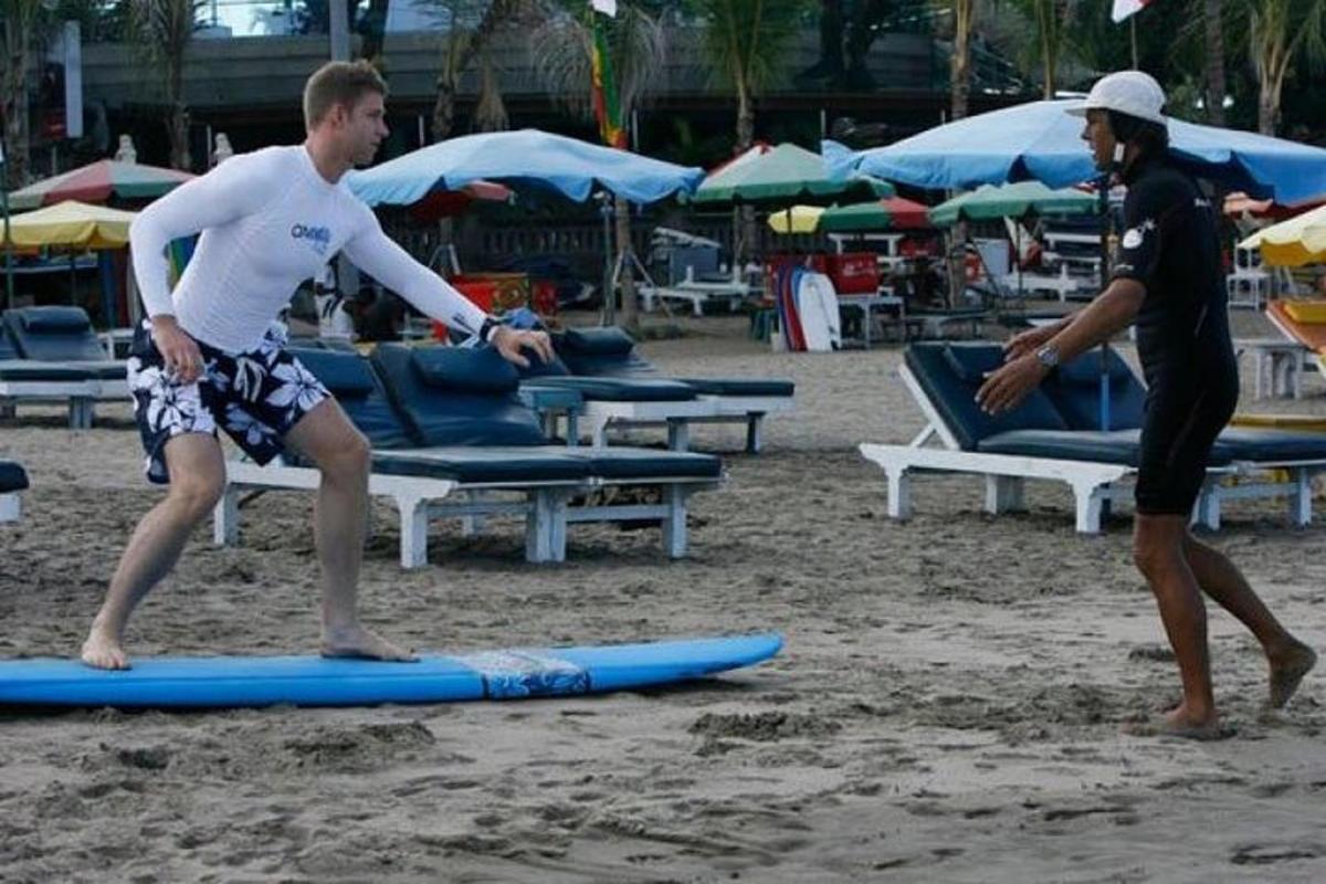 two men are standing on surfboards on the beach