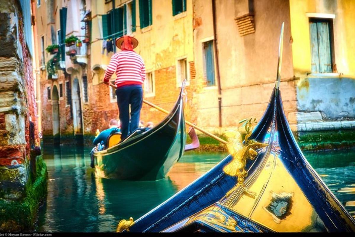 seorang pria berdiri di atas gondola di dalam air