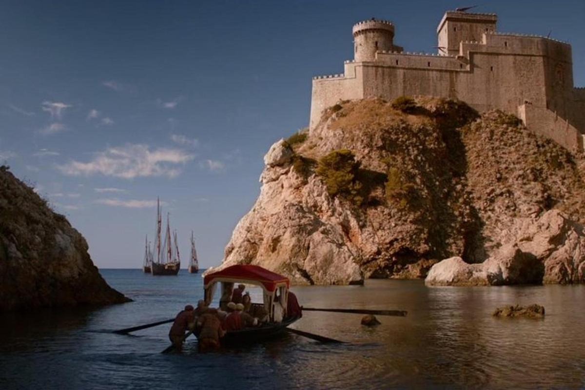 un gruppo di persone su una barca di fronte a un castello