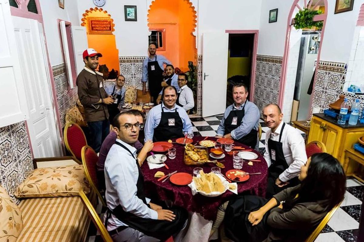 um grupo de pessoas sentadas ao redor de uma mesa com comida