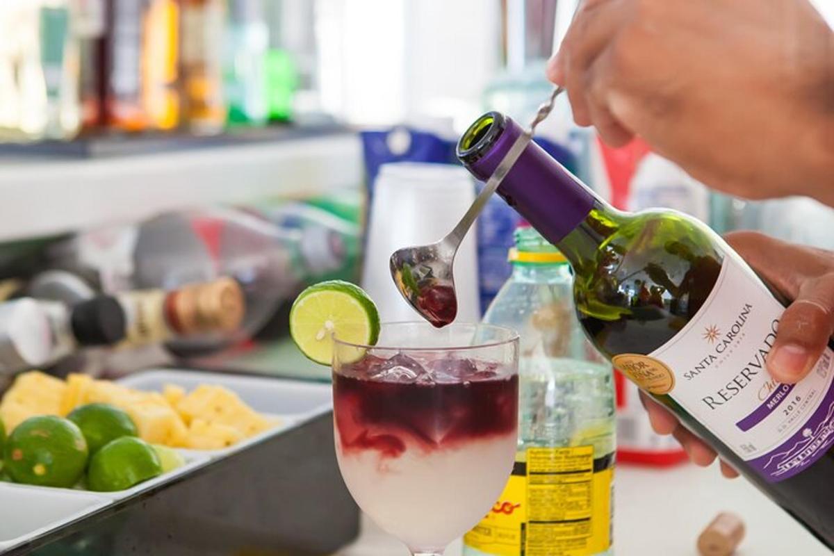 una persona que vierte una botella de vino en una bebida