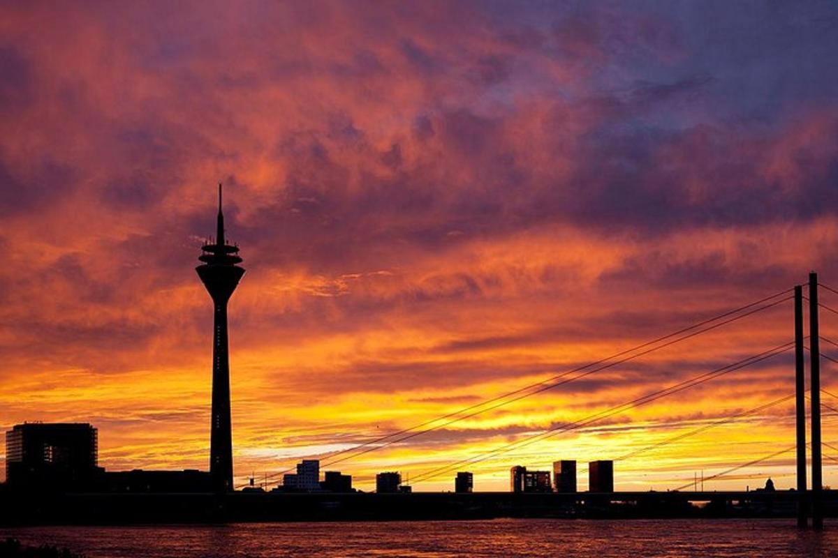 a city skyline with a tower at sunset