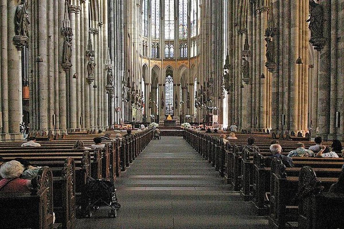 sekumpulan orang yang duduk di sebuah katedral