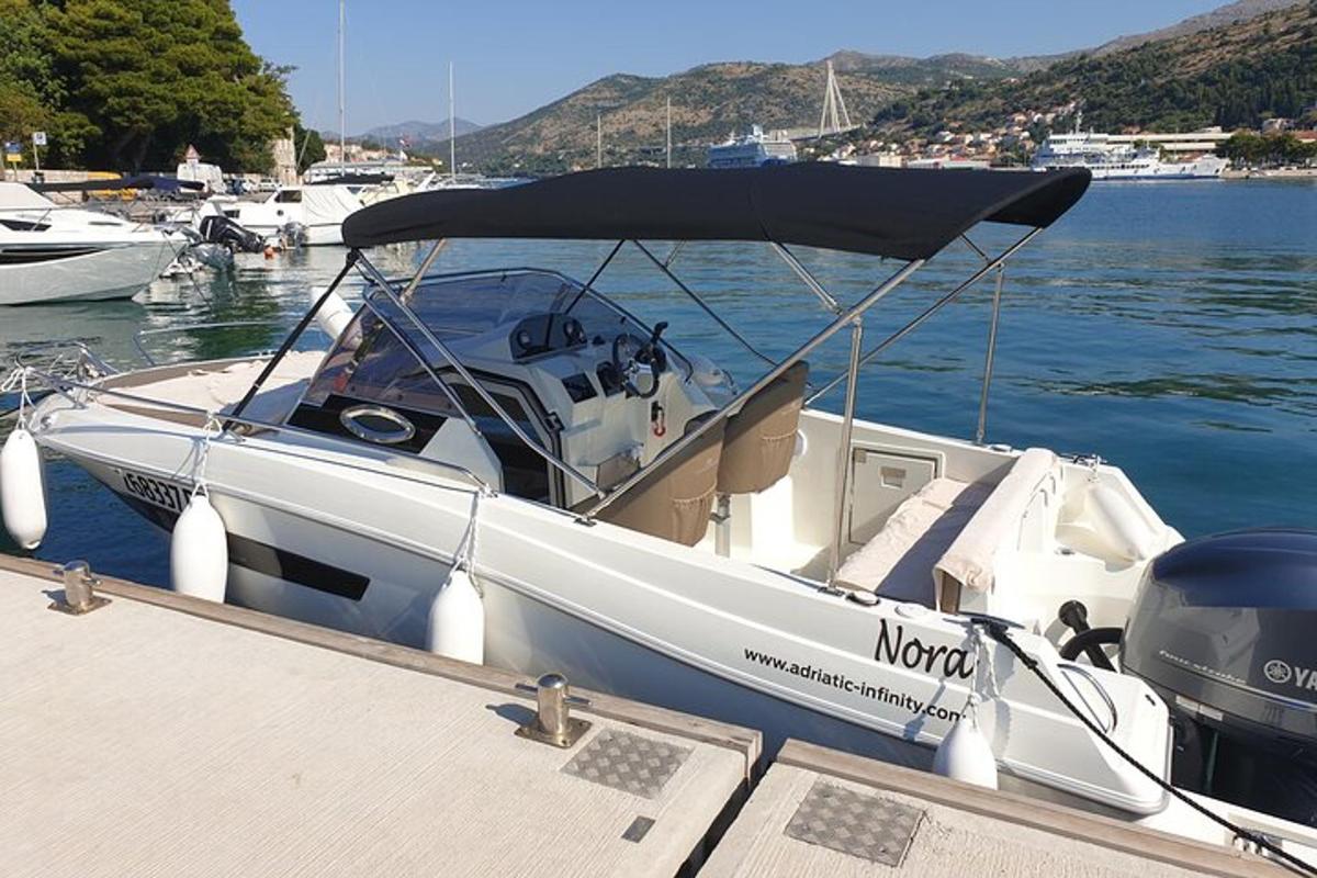 μια άσπρη βάρκα παρκαρισμένη σε μια αποβάθρα στο νερό