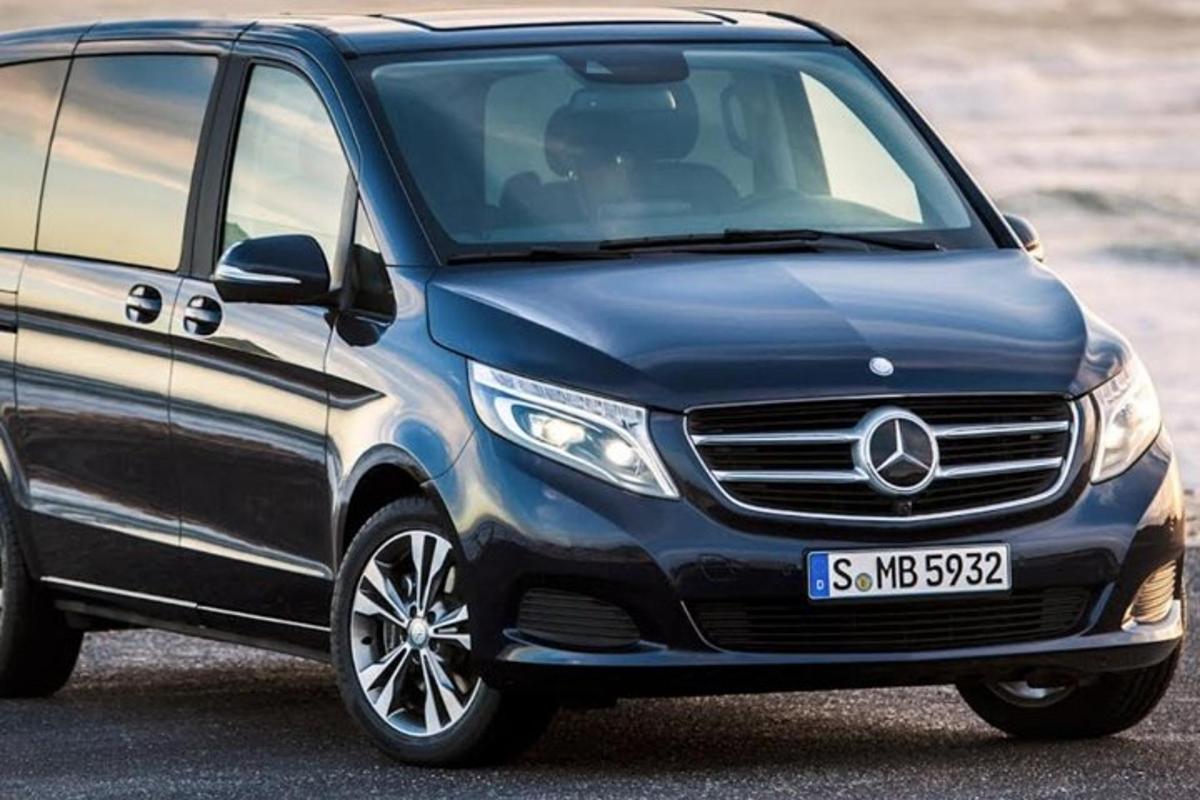 Modrá dodávka Mercedes Benz zaparkovaná vedle pláže