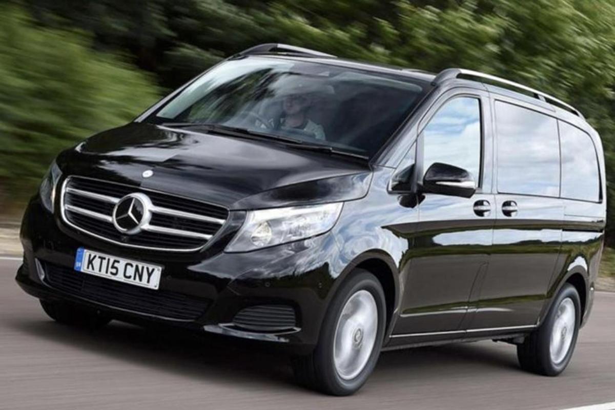 một chiếc xe tải mercedes màu đen đang chạy trên đường