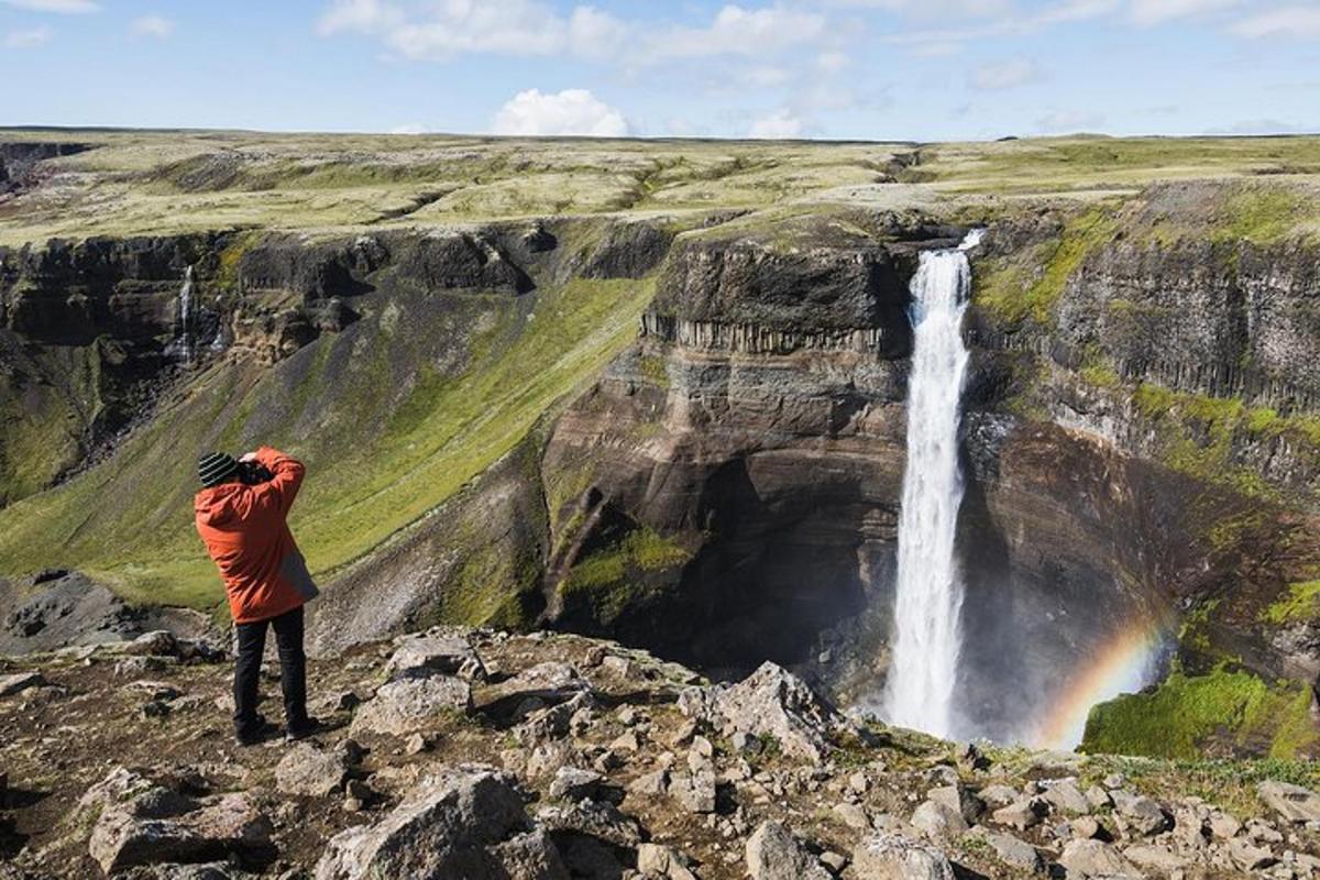 ein Mann, der ein Foto von einem Wasserfall macht