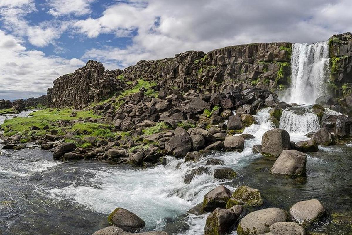 una cascada en la ladera de una montaña con rocas