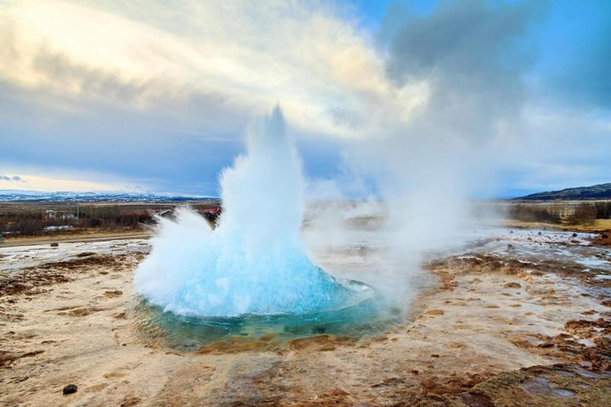 una erupción de géiser en medio de un campo