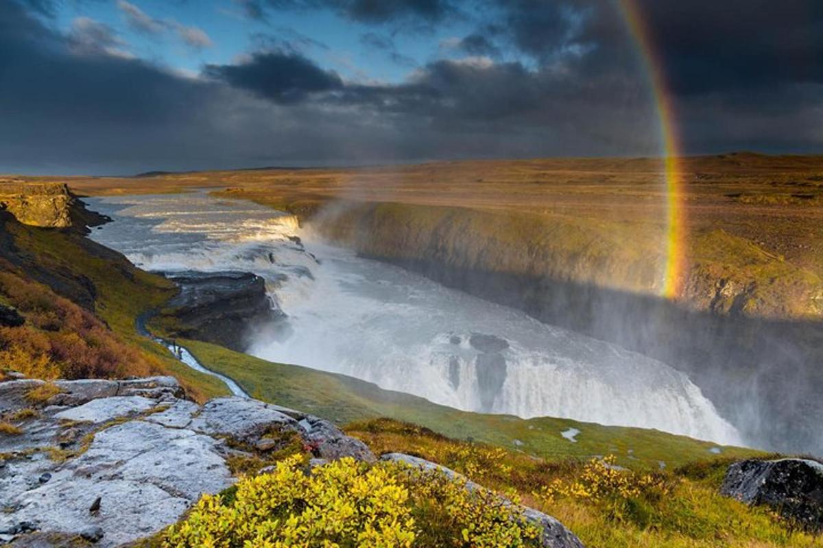 un arcoíris sobre una cascada y un río