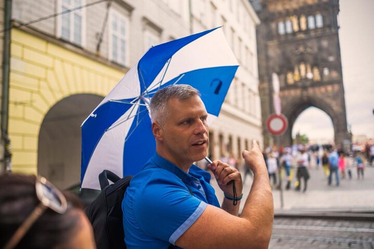 un uomo tiene in mano un ombrello blu e bianco