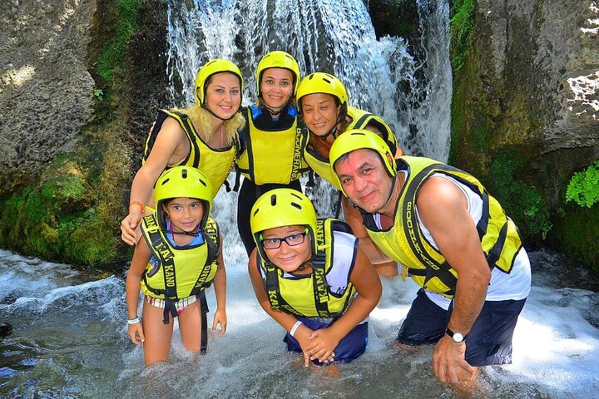 un gruppo di persone con caschi gialli in piedi in una cascata