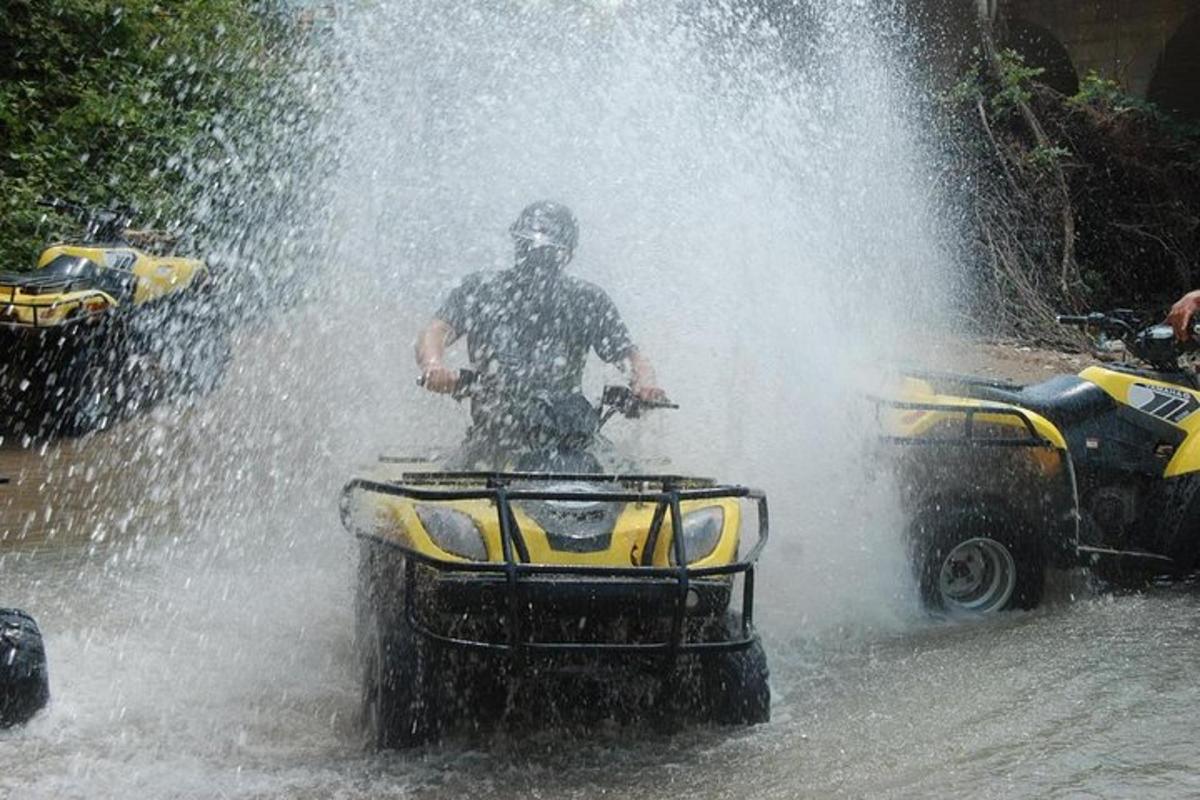 en mann som kjører en ATV gjennom en vannfontene