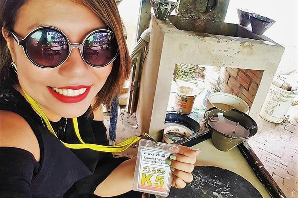 seorang wanita yang memakai kacamata hitam sedang memegang gantungan kunci