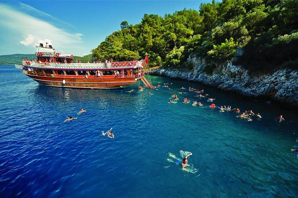 a group of people swimming in the water next to a boat