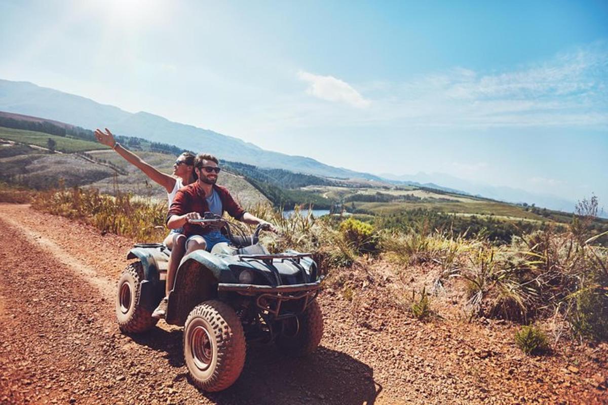 two people on a four wheeler on a dirt road