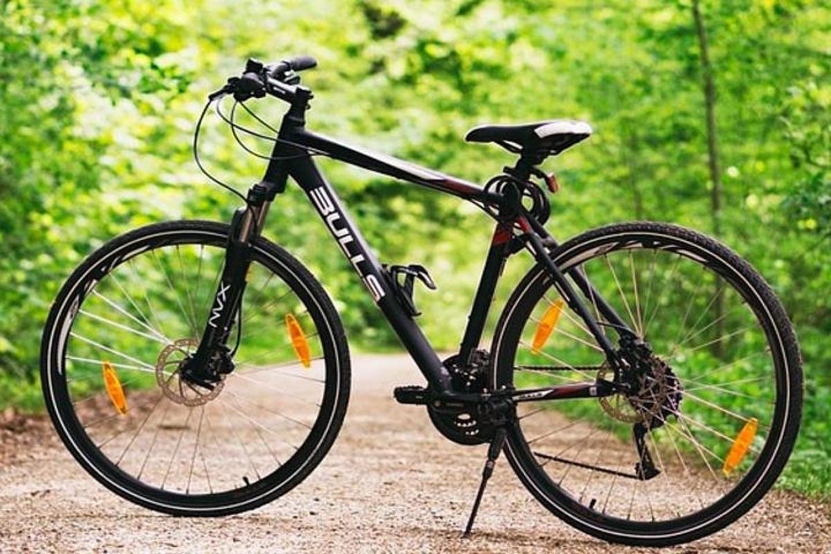 một chiếc xe đạp màu đen đỗ trên một con đường đất