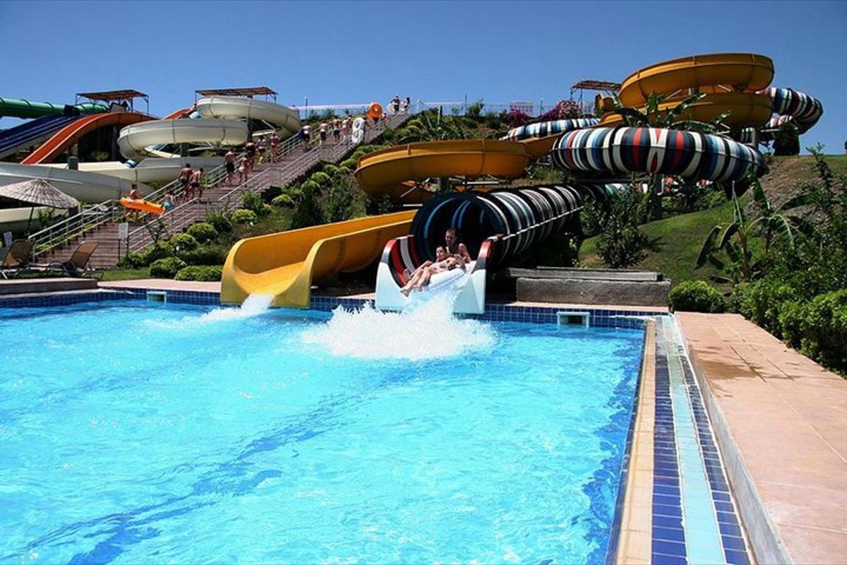 un tobogan cu apă într-un parc acvatic cu oameni pe el
