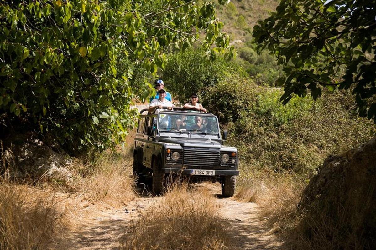a group of people riding in a jeep on a dirt road