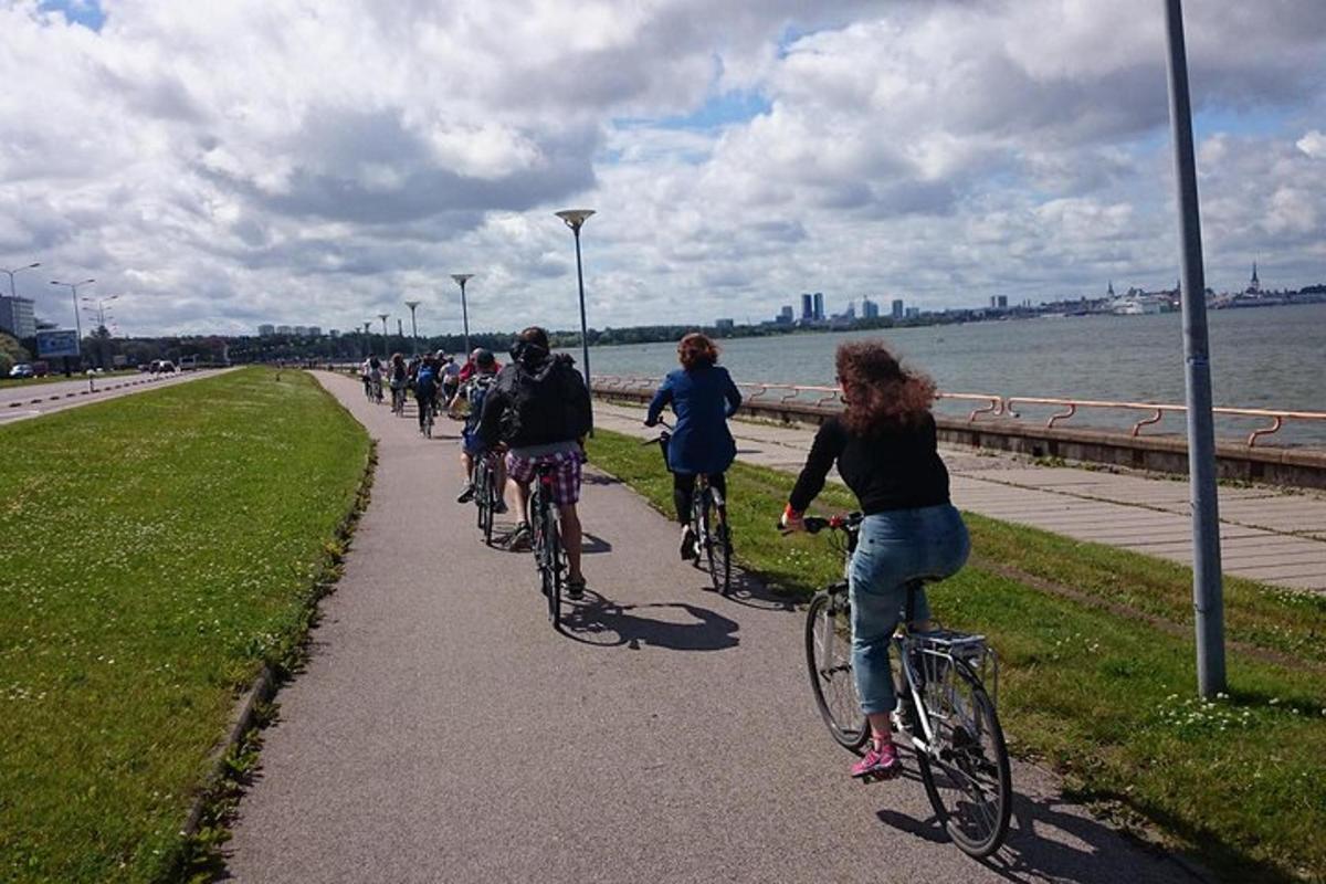 a group of people riding bikes down a sidewalk