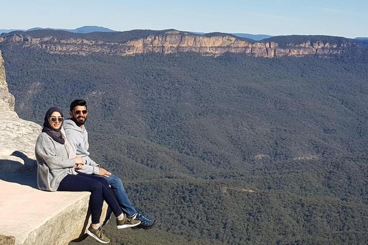 Un hombre y una mujer sentados en el borde de una montaña