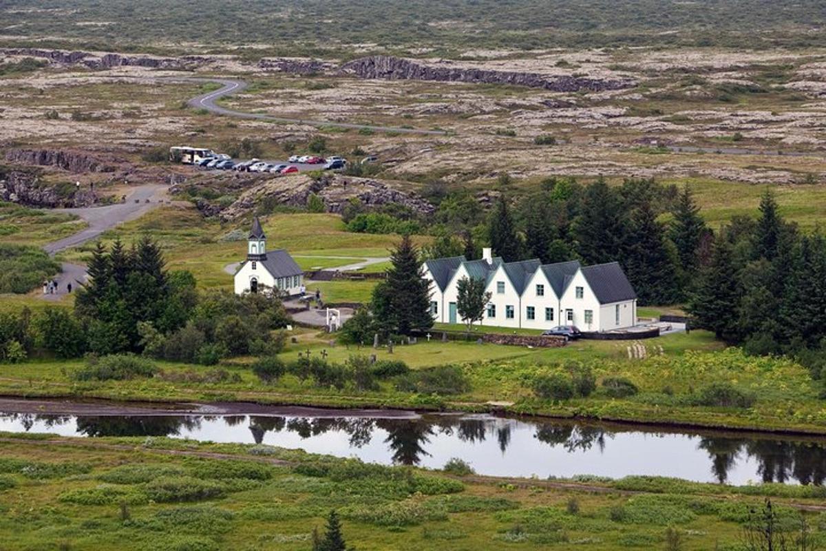 uma grande casa branca em uma colina próxima a um lago