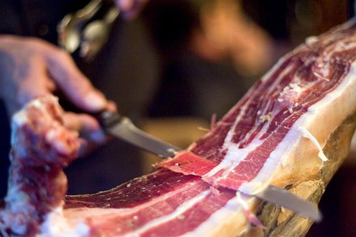 una persona che taglia un pezzo di carne con un coltello