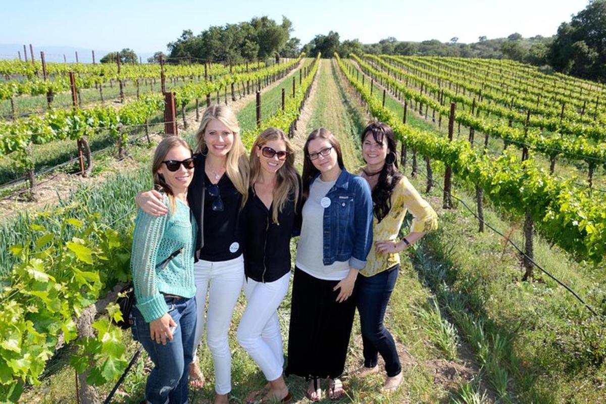 a group of women standing in a vineyard