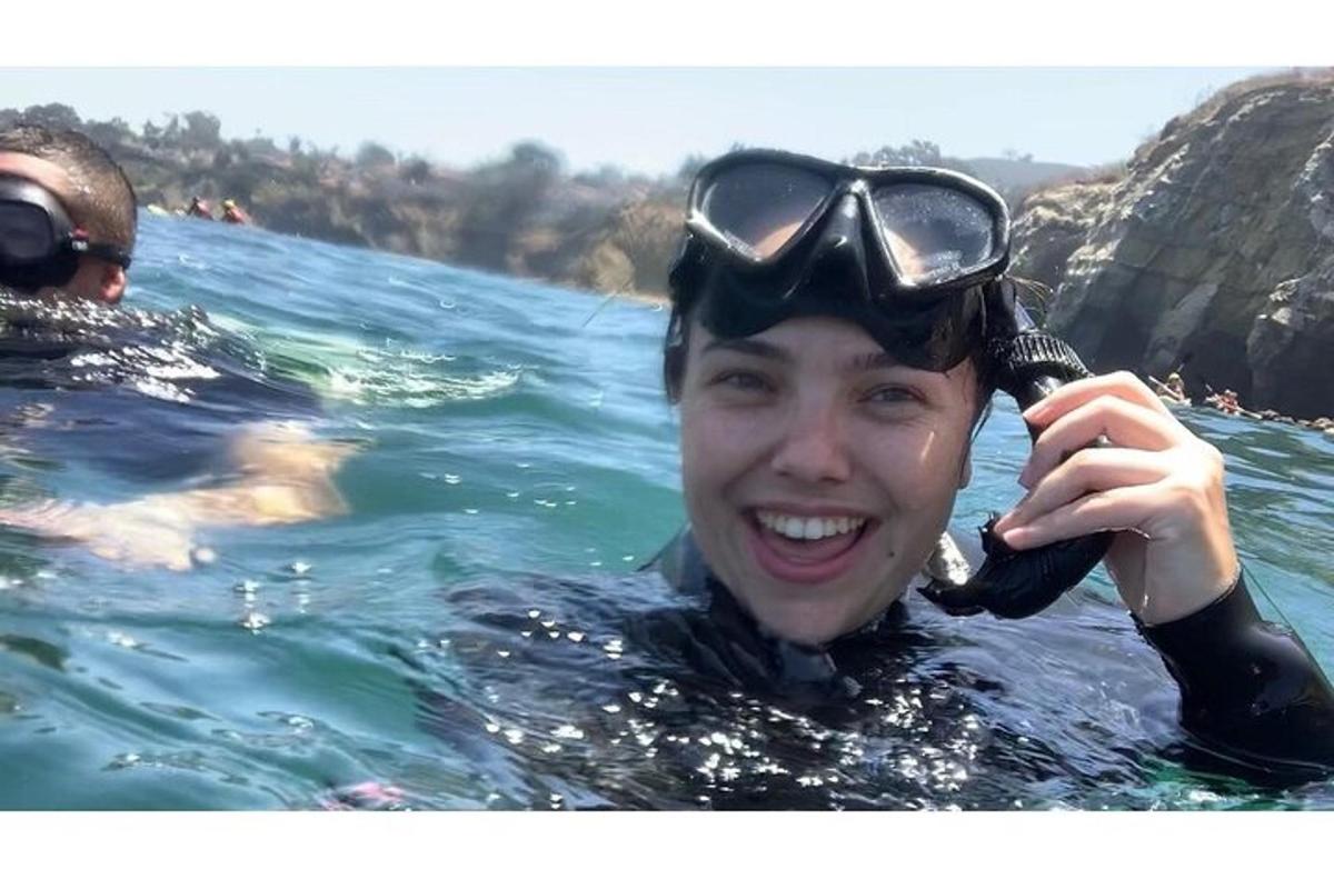 una persona in acqua con gli occhialini in testa
