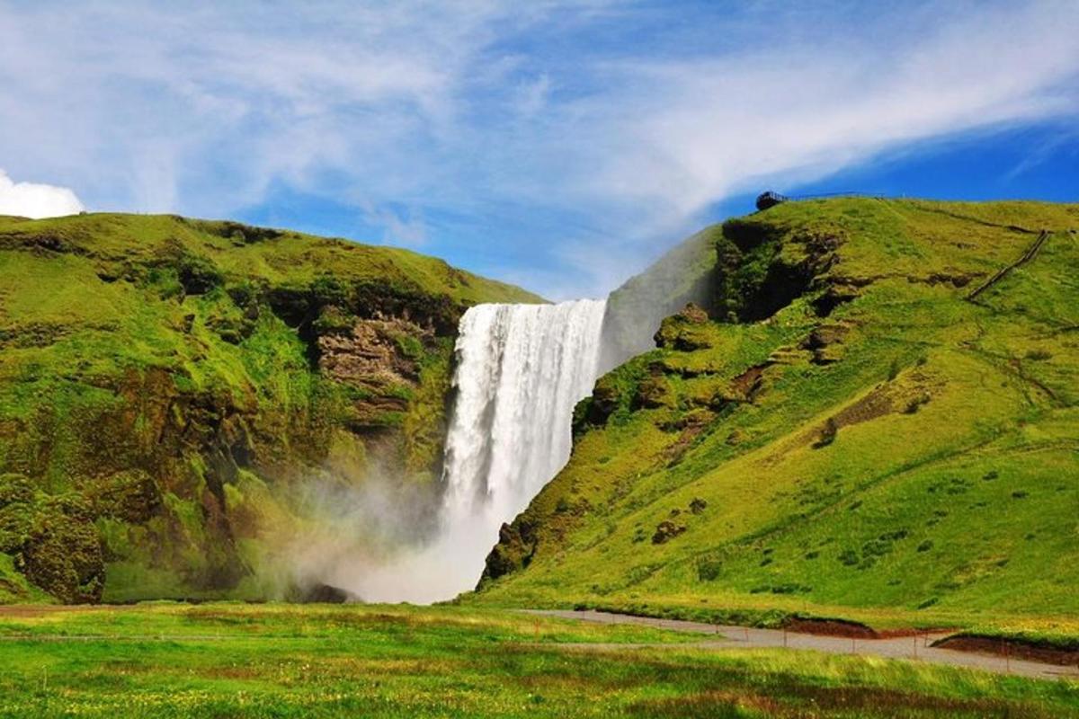 una cascata sul fianco di una collina con erba verde