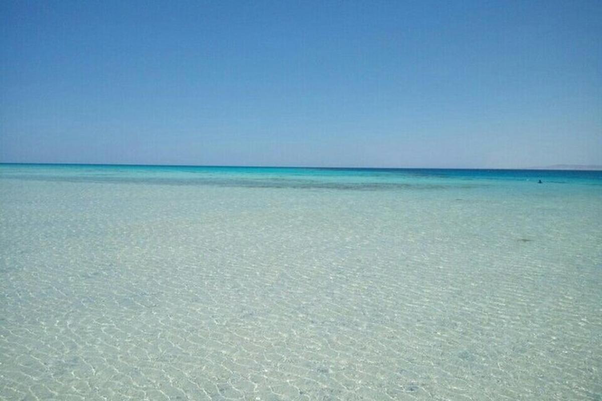 o plajă cu apă limpede și cer albastru
