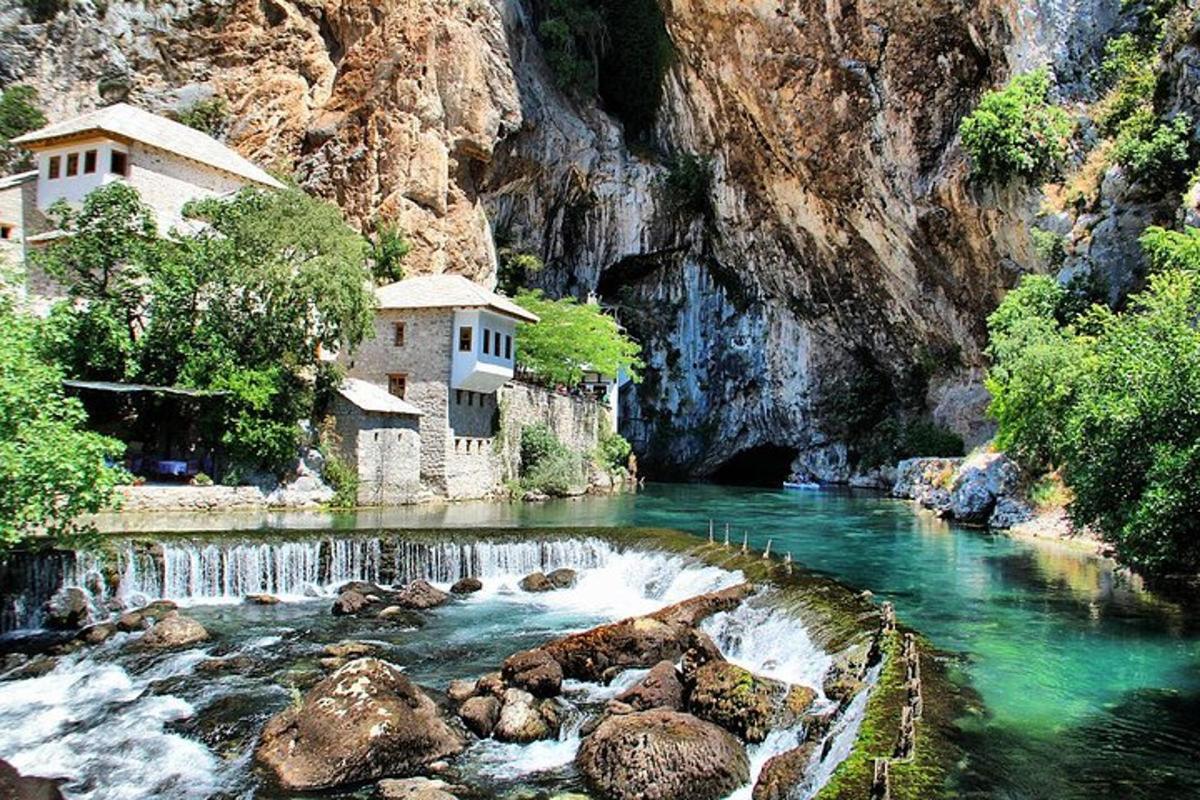 un fiume con un edificio sul fianco di una montagna
