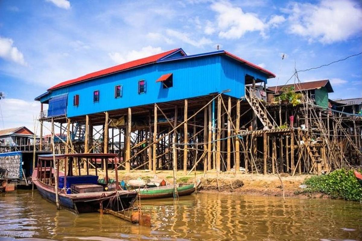 a blue building on the shore of a body of water