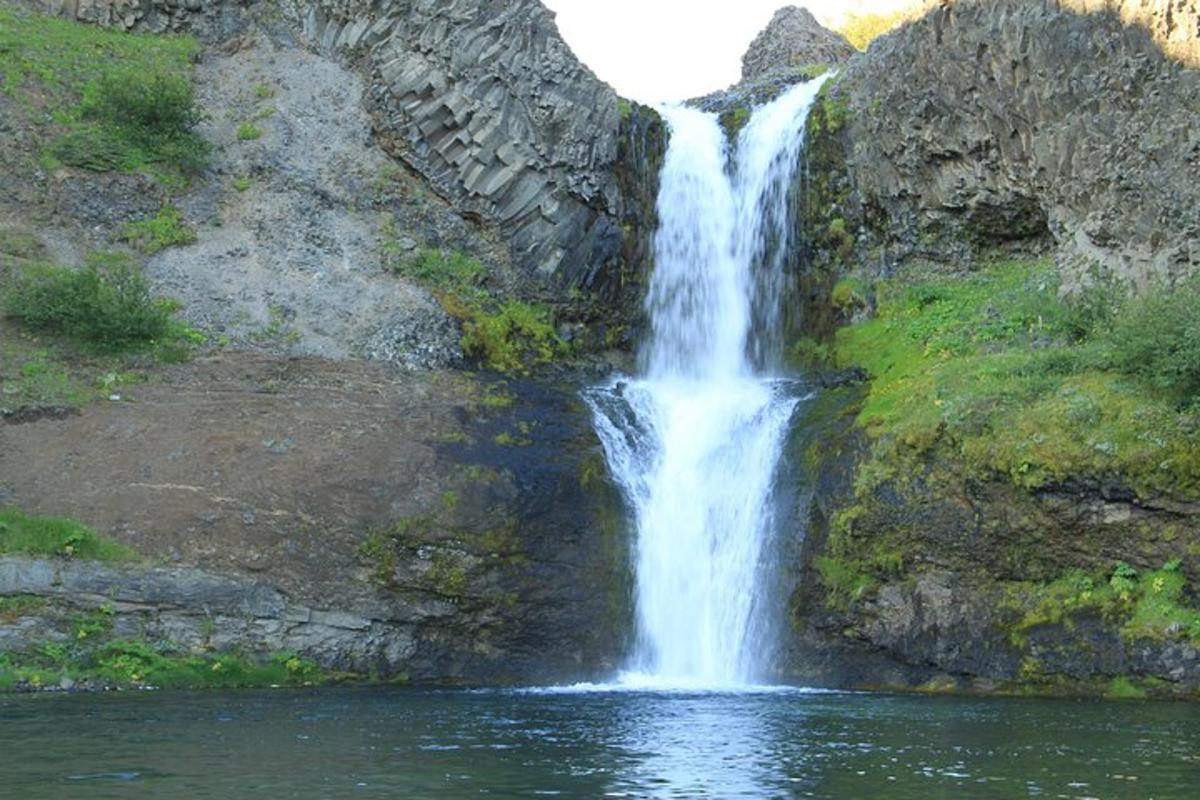 una cascata sul fianco di una montagna con acqua