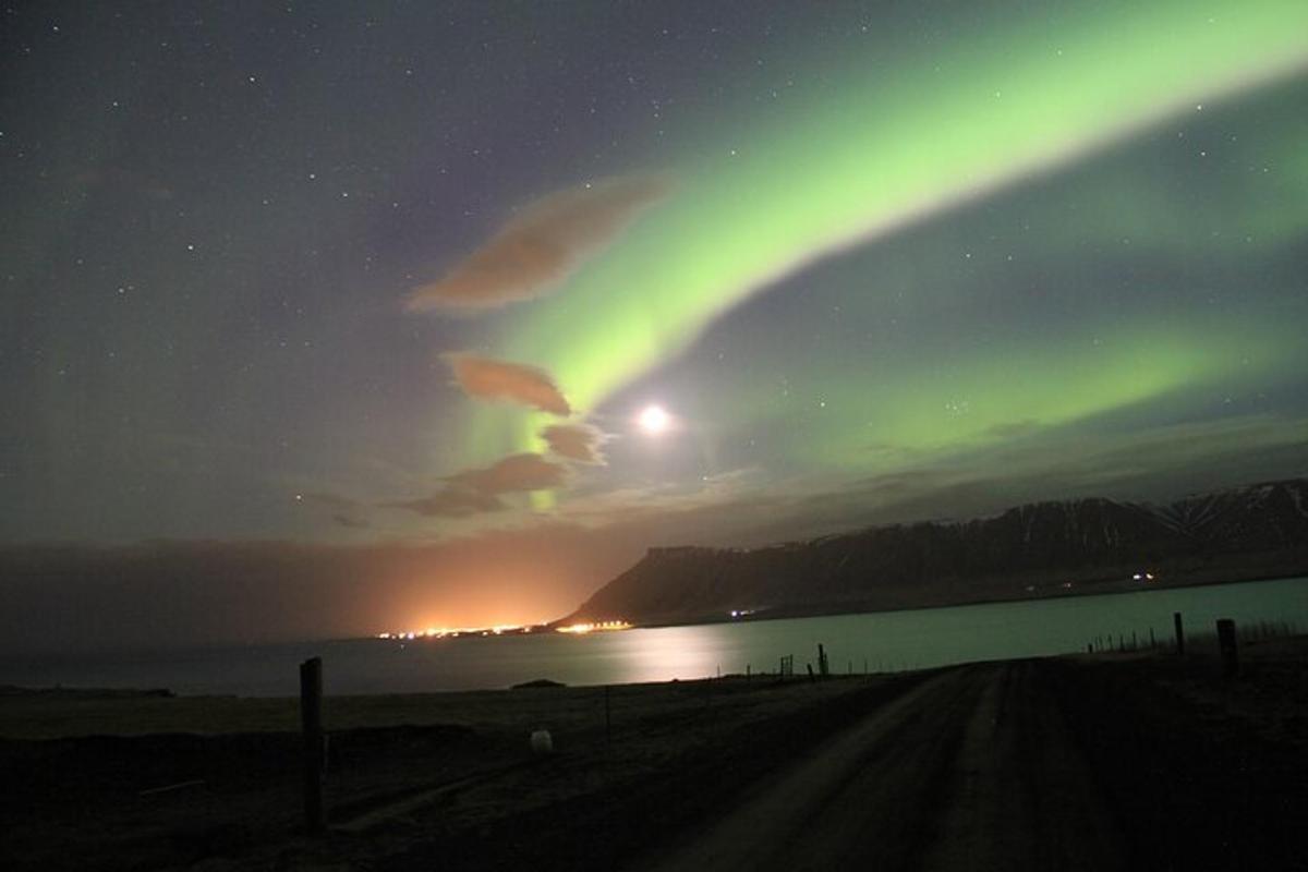 uma aurora no céu sobre uma praia à noite