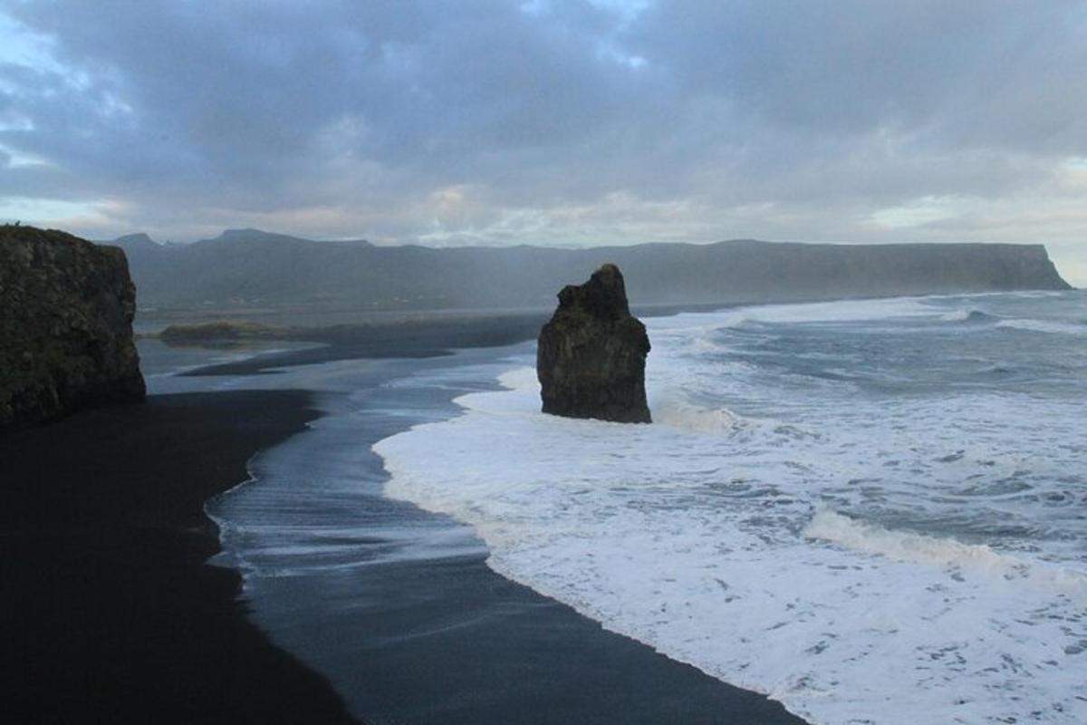 una spiaggia con una grande roccia nell'oceano