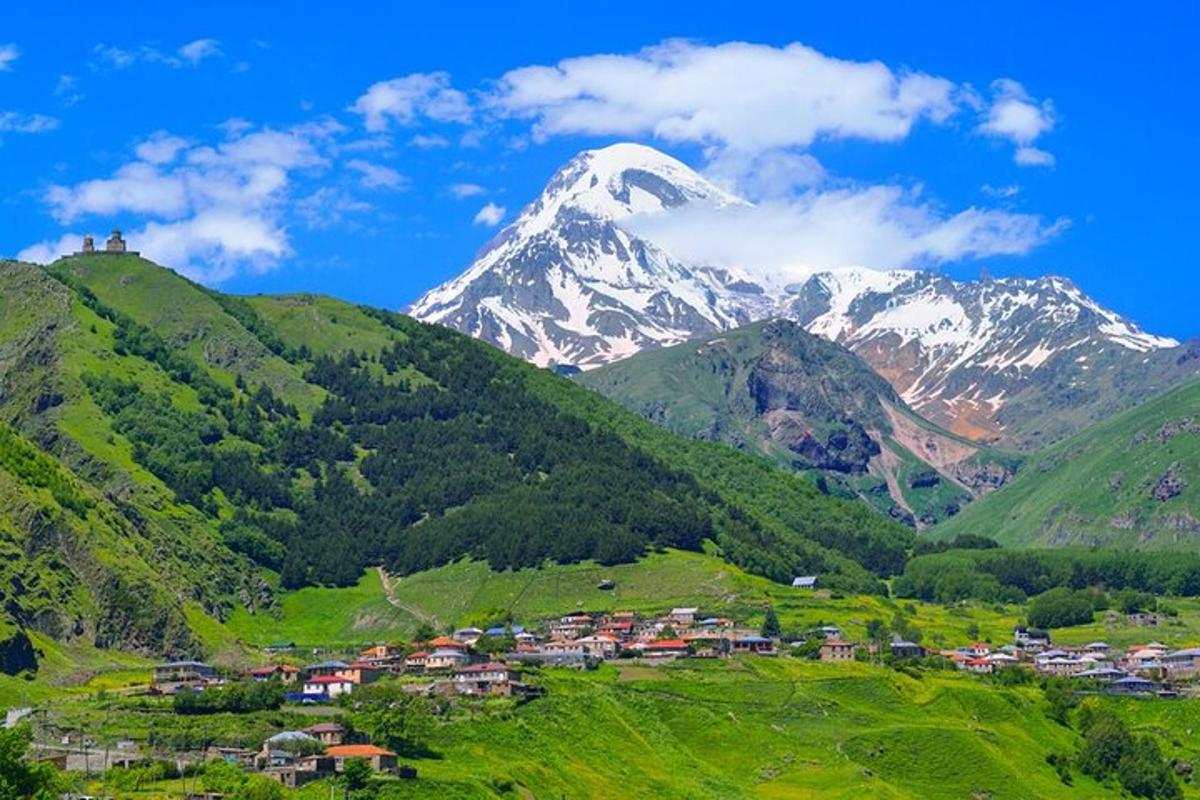 ein Berg in der Ferne mit einem Dorf in einem Tal