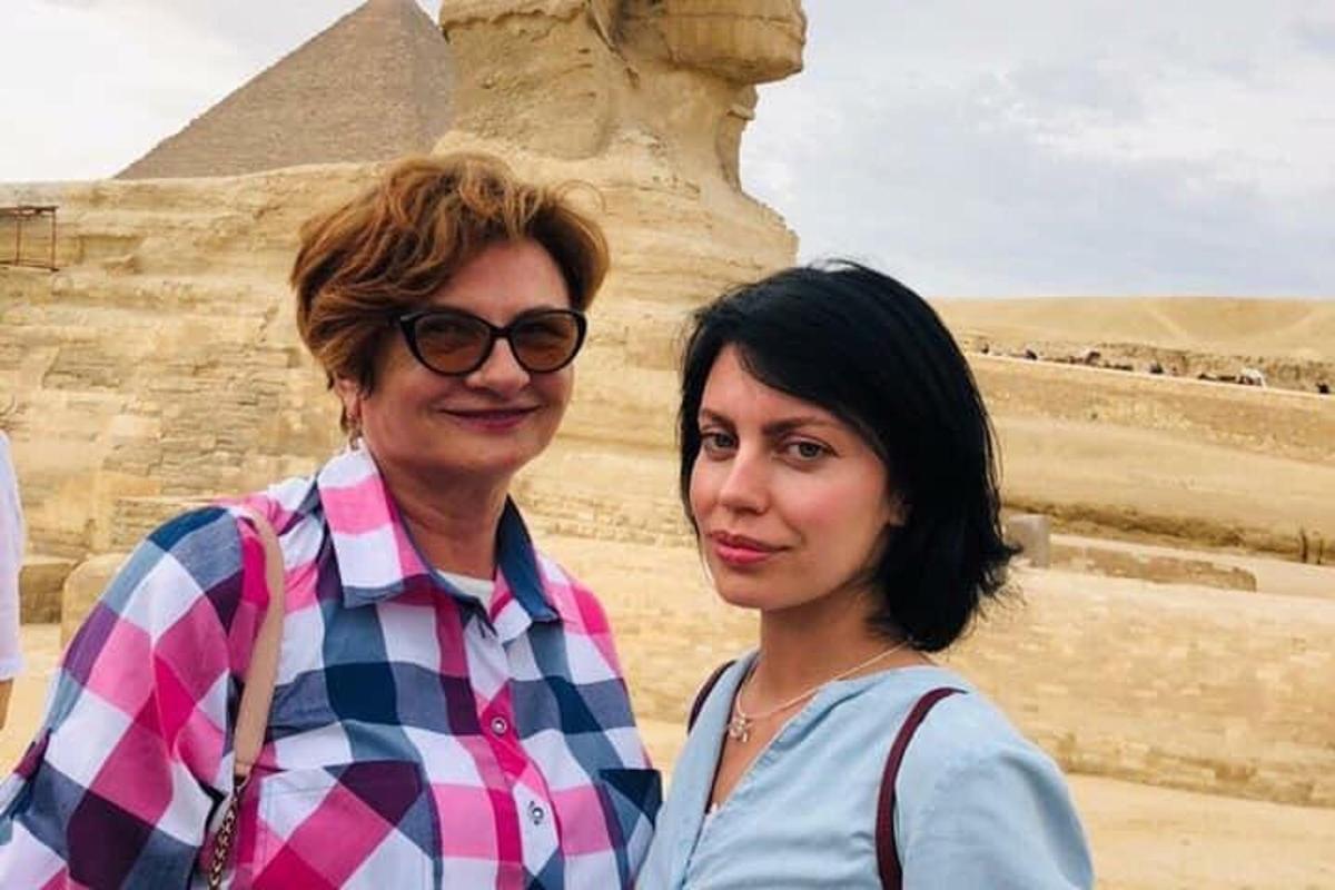 to kvinner som står foran pyramidene