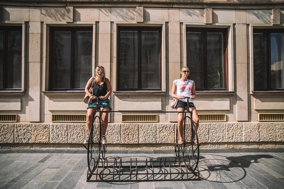dvě ženy sedící na kolech před budovou